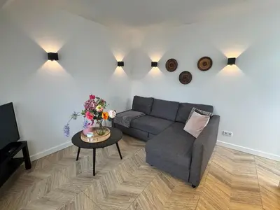 a living room with a couch and a table at Homes by the C in Zandvoort