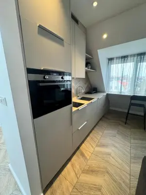 a kitchen with white cabinets and a stove top oven at Homes by the C in Zandvoort
