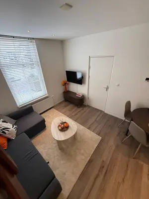 a living room with a couch and a table at Homes by the C in Zandvoort