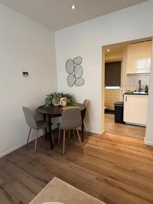 a dining room with a table and chairs and a kitchen at Homes by the C in Zandvoort