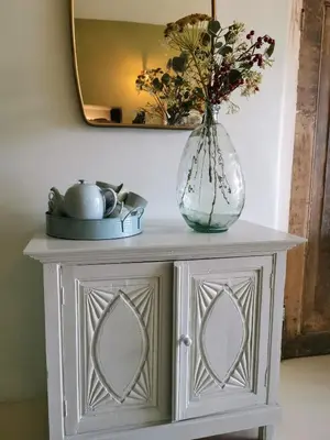 a vase of flowers on a table with a mirror at Slapen aan de Sluis in Utrecht