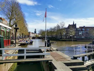 a river with people on a boat in a city at Slapen aan de Sluis in Utrecht