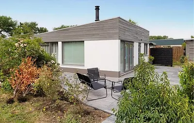 a house with two chairs sitting on a patio at 2 Bedroom Cozy Home In Noordwijkerhout in Noordwijkerhout