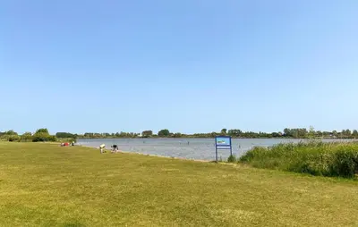 a grassy field next to a body of water at 2 Bedroom Cozy Home In Noordwijkerhout in Noordwijkerhout