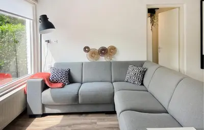 a living room with a gray couch and a window at 2 Bedroom Nice Home In Noordwijkerhout in Noordwijkerhout
