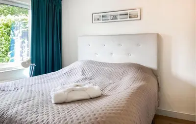 a white bed with a white blanket and a window at 2 Bedroom Nice Home In Noordwijkerhout in Noordwijkerhout