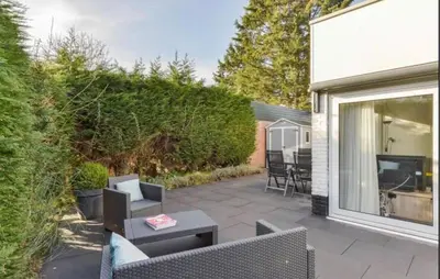 a patio with chairs and a table and a television at 2 Bedroom Nice Home In Noordwijkerhout in Noordwijkerhout