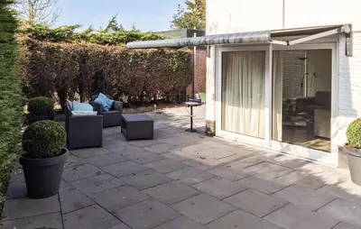 a patio with a sliding glass door and a couch at 2 Bedroom Nice Home In Noordwijkerhout in Noordwijkerhout
