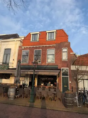 a building with tables and chairs in front of it at Apartement hotel Stays by ADM in Leiden