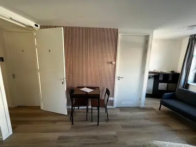 a living room with a table and a blue couch at Apartement hotel Stays by ADM in Leiden