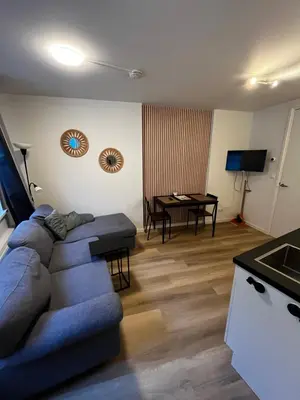 a living room with a blue couch and a table at Apartement hotel Stays by ADM in Leiden