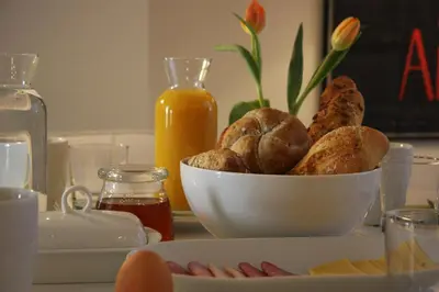 a table with a bowl of bread and orange juice at B&B Keizers Canal in Amsterdam