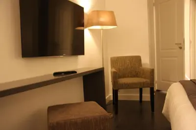 a hotel room with a bed and a chair and a television at B&B Keizers Canal in Amsterdam