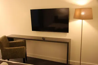 a room with a tv and a chair and a table at B&B Keizers Canal in Amsterdam