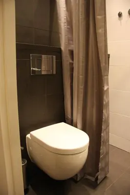a white toilet in a bathroom with a shower at B&B Keizers Canal in Amsterdam