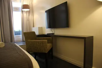 a hotel room with a tv and a desk with a chair at B&B Keizers Canal in Amsterdam