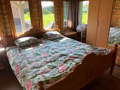a bedroom with a large bed with flowers on it at Have a nice stay! - Vakantiehuis 't Klavertje in Noordwijk
