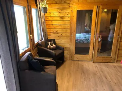 a living room with two chairs and a bedroom at Have a nice stay! - Vakantiehuis 't Klavertje in Noordwijk