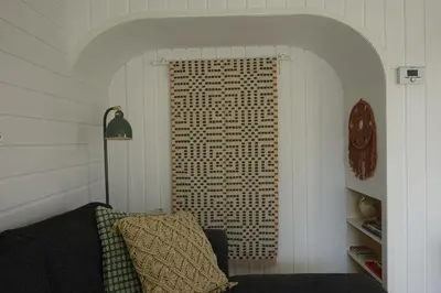 a room with a couch and a clock on a wall at Ithaka Beach House, unieke plek met vrij parkeren! in Noordwijk
