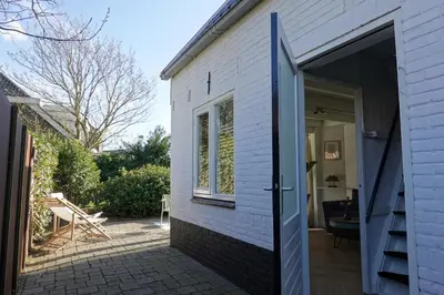 an open door to a house with a patio at Ithaka Beach House, unieke plek met vrij parkeren! in Noordwijk