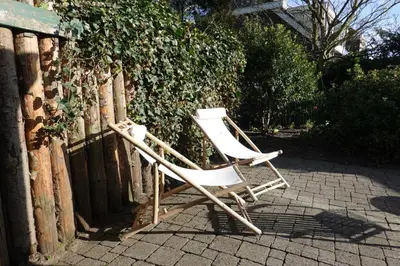 two white chairs sitting next to a fence at Ithaka Beach House, unieke plek met vrij parkeren! in Noordwijk