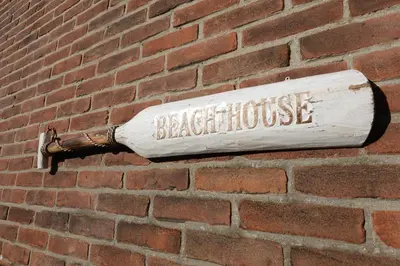 a brick wall with a white bat on it at Ithaka Beach House, unieke plek met vrij parkeren! in Noordwijk