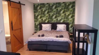 a bedroom with a bed with a large painting on the wall at Blossom Barn Lodges in Oudewater
