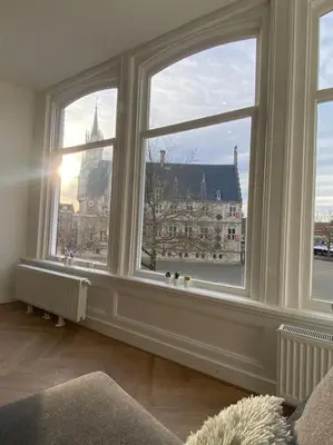 a room with large windows with a view of a city at Apartement City Center Gouda: View Deluxe in Gouda