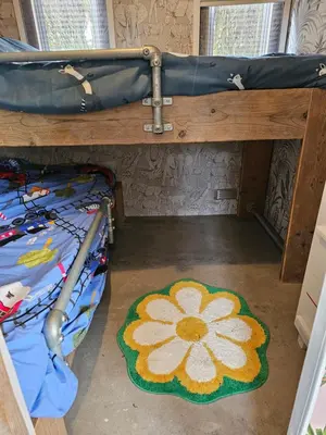 a room with a bunk bed with a flower rug at Slapen in Tuitje in Tuitjenhorn