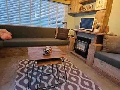 a living room with a couch and a fireplace at Slapen in Tuitje in Tuitjenhorn
