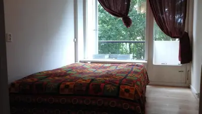 a bedroom with a bed in front of a window at Studio 99 in Amsterdam