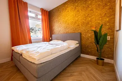 a bed in a room with a yellow wall at Hello Stay Utrecht in Utrecht