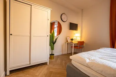 a bedroom with a white closet and a clock on the wall at Hello Stay Utrecht in Utrecht