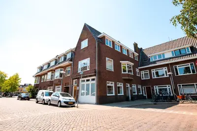 two cars parked in front of a brick building at Hello Stay Utrecht in Utrecht