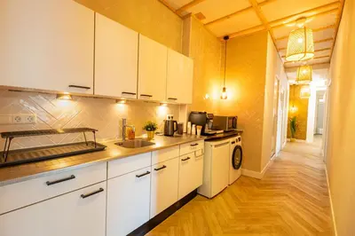 a kitchen with white cabinets and a sink at Hello Stay Utrecht in Utrecht