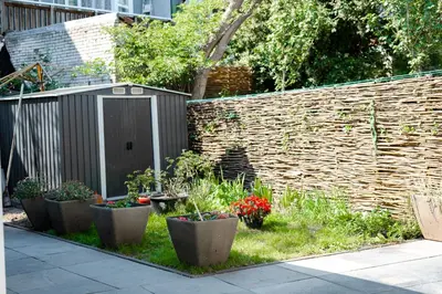 a garden with a fence and some plants at Hello Stay Utrecht in Utrecht