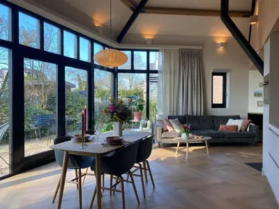 a living room with a table and a couch at Ons Huisje Achter - De Hooischuur in Noordwijkerhout
