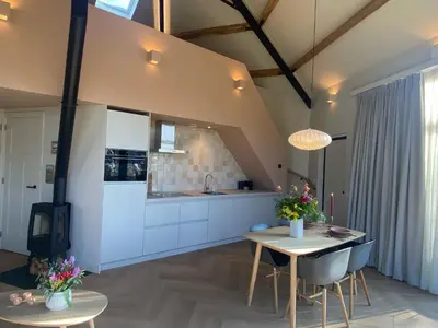 a kitchen and dining room with a table and chairs at Ons Huisje Achter - De Hooischuur in Noordwijkerhout