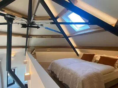 a bedroom with a bed and a window at Ons Huisje Achter - De Hooischuur in Noordwijkerhout