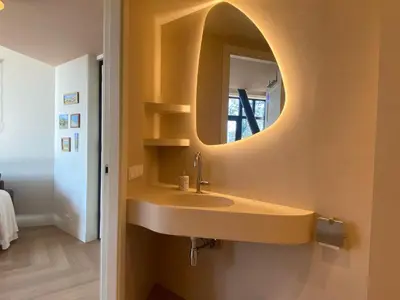 a bathroom with a sink and a mirror on the wall at Ons Huisje Achter - De Hooischuur in Noordwijkerhout