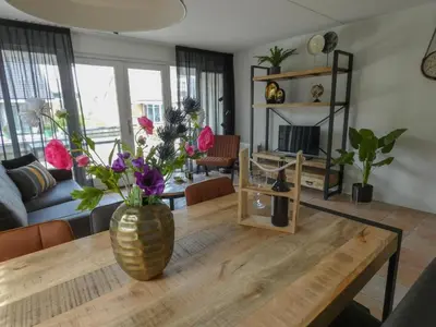 a living room with a vase of flowers on a wooden table at Busch en Dam in Uitgeest