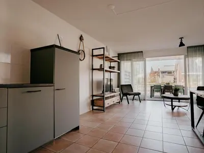 a kitchen with a refrigerator and a dining room at Busch en Dam in Uitgeest
