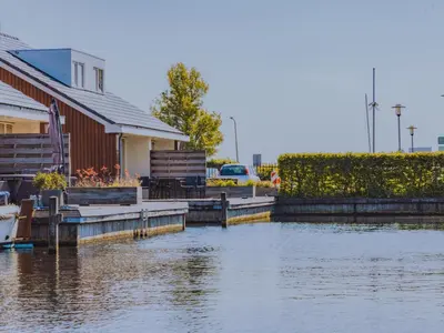 a body of water next to a house at Busch en Dam in Uitgeest