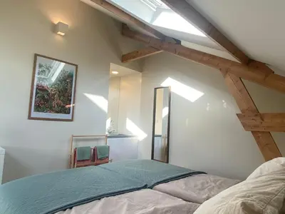 a bedroom with a bed and a skylight at Ons Huisje Achter in Noordwijkerhout
