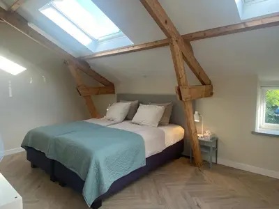 a bed in a room with a skylight at Ons Huisje Achter in Noordwijkerhout