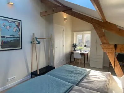 a bedroom with a bed and a desk in it at Ons Huisje Achter in Noordwijkerhout