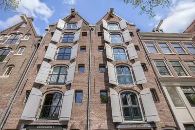 a tall brick building with many windows at Storehouse Studios in Amsterdam