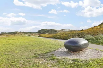 a large gray object sitting on the grass next to a road at Appartement Zandkorrel in Schoorl
