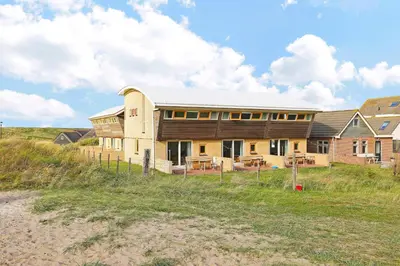 a house on the beach next to a field at Appartement Zandkorrel in Schoorl