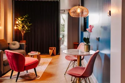 a living room with a table and chairs at Hotel Keur - Apartments in Zandvoort